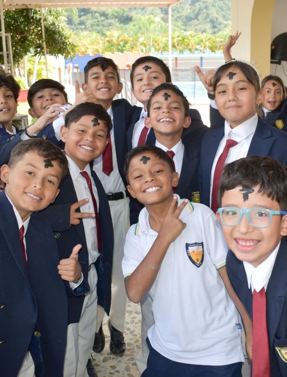 Estudiantes del Colegio Tolimense sonríen a la cámara con la cruz de ceniza en la frente, tras participar en la celebración del Miércoles de Ceniza, inicio de la Cuaresma, como parte de la formación evangelizadora de la institución.